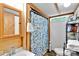 Clean bathroom with blue floral shower curtain, wooden vanity, and functional fixtures at 2289 Mccloud St, Denver, NC 28037