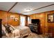 Serene bedroom featuring wood paneling, dog kennel, dark dresser, and a comfortable bed at 2289 Mccloud St, Denver, NC 28037