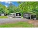 Charming home with a wooden deck and a gravel driveway surrounded by lush greenery and a storage shed at 2289 Mccloud St, Denver, NC 28037