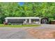Charming home with a wooden deck and a gravel driveway surrounded by lush greenery and a storage shed at 2289 Mccloud St, Denver, NC 28037