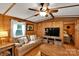 Cozy living room with wood paneling, leather sofa, ceiling fan, and access to the main bedroom at 2289 Mccloud St, Denver, NC 28037