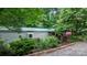 View of the exterior of a home with lush garden, bushes, and a gravel driveway at 2951 Evergreen Trl, Vale, NC 28168