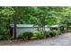 Exterior view of a home with a green roof, complemented by lush landscaping and a gravel driveway at 2951 Evergreen Trl, Vale, NC 28168