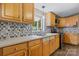 Bright kitchen featuring wooden cabinets, modern appliances, and patterned tile backsplash at 2951 Evergreen Trl, Vale, NC 28168