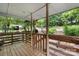 View of a covered porch with a wooden railing and views of the surrounding greenery at 2951 Evergreen Trl, Vale, NC 28168
