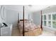 Bedroom with a beautiful four-poster bed with floral bedding, white dresser and shuttered windows create a serene ambiance at 2972 Kaneland Ct, Rock Hill, SC 29732