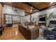 Open-concept living room with exposed wood ceiling, hardwood floors, and sliding door to the bedroom at 310 Arlington Ave # 409, Charlotte, NC 28203