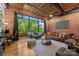 Bright living room with large window, exposed brick, hardwood floors, and modern furnishings at 310 Arlington Ave # 409, Charlotte, NC 28203