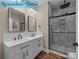 Bathroom featuring a double sink vanity with black fixtures and a glass-enclosed shower with marble tiling at 317 N Cemetery St, Richfield, NC 28137