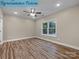 A bright bedroom featuring wood-look flooring, a ceiling fan, and a window to let in natural light at 317 N Cemetery St, Richfield, NC 28137