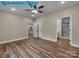 Bedroom boasting wood-look flooring, ceiling fan, access to a bathroom with a shower, and an open kitchen area at 317 N Cemetery St, Richfield, NC 28137