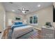 This staged bedroom has beautiful wood-look flooring, a ceiling fan, and a large window that offers lots of natural light at 317 N Cemetery St, Richfield, NC 28137