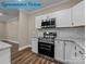 Well-equipped kitchen with stainless steel appliances, granite counters, white cabinets, and hardwood floors at 317 N Cemetery St, Richfield, NC 28137