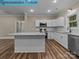 Well-equipped kitchen featuring stainless steel appliances, white cabinets, granite countertops, and wood flooring at 317 N Cemetery St, Richfield, NC 28137