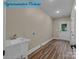 Bright laundry room featuring a utility sink, wood-look flooring, and exterior door for added convenience at 317 N Cemetery St, Richfield, NC 28137