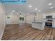 Bright living room with hardwood floors and a ceiling fan connects to a modern kitchen with an island at 317 N Cemetery St, Richfield, NC 28137