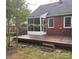 View of the backyard featuring a wooden deck and a screened porch attached to the brick house at 3726 The Plaza None, Charlotte, NC 28205