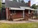 View of brick house with awning covered porch, chimney, and a convenient outdoor stairway at 3726 The Plaza None, Charlotte, NC 28205