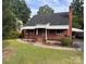 Charming brick home featuring a well-maintained lawn, a chimney, and awning-covered porches at 3726 The Plaza None, Charlotte, NC 28205