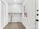 Bright laundry room with wood-look flooring, window, cabinets, and plumbing fixtures for appliances at 3726 The Plaza None, Charlotte, NC 28205