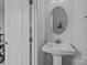 Tasteful powder room showcasing a pedestal sink, elegant mirror, and refined fixtures at 3737 S Tryon St, Charlotte, NC 28217