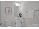 Clean bathroom with a white vanity, framed mirror, toilet, and fresh towel at 3737 S Tryon St, Charlotte, NC 28217