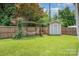 Fenced backyard features a storage shed, hammock, and manicured lawn at 4044 Somerdale Ln, Charlotte, NC 28205
