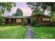 Traditional brick home with mature trees, lush lawn and a sidewalk leading to the front door at 4044 Somerdale Ln, Charlotte, NC 28205