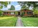 Charming brick home with a well-manicured lawn and mature trees providing shade at 4044 Somerdale Ln, Charlotte, NC 28205