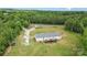 Aerial view of a well-maintained home with a deck and yard, complemented by vibrant greenery all around at 4518 Logging Rd, Lancaster, SC 29720