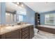 Bathroom featuring double sinks with dark cabinetry and a separate tub and shower at 4518 Logging Rd, Lancaster, SC 29720