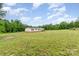 View of house on a large lot with green grass and trees in the background, blue skies and clouds at 4518 Logging Rd, Lancaster, SC 29720
