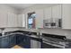 Bright kitchen with black countertops, two-tone cabinets, and a window over the sink at 482 New Bern Station Ct, Charlotte, NC 28209