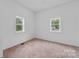 Cozy bedroom with two windows, soft carpeting, and neutral walls at 506 N Styers St, Cherryville, NC 28021