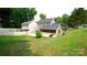 A large backyard with a patio, partial fence and mature trees offers space for relaxation at 7046 Dorn Cir, Charlotte, NC 28212