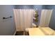 Bathroom featuring toilet, shower, shelves and a decorative white shower curtain at 7046 Dorn Cir, Charlotte, NC 28212