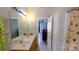Bathroom with double sinks, a large mirror, and a separate shower with palm tree curtain at 7046 Dorn Cir, Charlotte, NC 28212