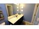 Bathroom with black cabinetry, stylish decor, and a blue wall with vinyl flooring at 7046 Dorn Cir, Charlotte, NC 28212