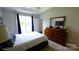 This bedroom has a nice wood dresser and mirror with a tray ceiling and natural light at 7046 Dorn Cir, Charlotte, NC 28212