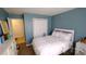 This bedroom features blue walls, wood floors and a queen size bed with white linens at 7046 Dorn Cir, Charlotte, NC 28212