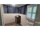 Small bathroom with a wood cabinet vanity, decorative wallpaper, and a circular mirror at 804 N Main St, Oakboro, NC 28129