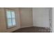 Bedroom featuring horizontal wall paneling, a window with plantation shutters and hard surface floors at 804 N Main St, Oakboro, NC 28129