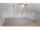 Attic bedroom with a ceiling fan, wood-look walls, and built-in storage at 804 N Main St, Oakboro, NC 28129