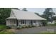 Traditional home featuring a metal roof, covered porch, and rocking chairs at 804 N Main St, Oakboro, NC 28129