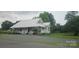 The home features a beautiful lawn, mature trees, covered porch, and convenient gravel driveway at 804 N Main St, Oakboro, NC 28129