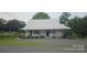 Charming one story home featuring a metal roof, fresh landscaping and rocking chair front porch at 804 N Main St, Oakboro, NC 28129