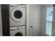 Stacked washer and dryer in laundry area next to a white shuttered window at 804 N Main St, Oakboro, NC 28129