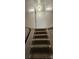 Carpeted basement stairs with modern black railing and wood-look walls at 804 N Main St, Oakboro, NC 28129