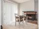 Cozy dining area with a classic brick fireplace and lots of natural light from the large windows at 8208 Cedar Glen Dr, Charlotte, NC 28212