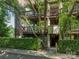 Close-up of the exterior of a condo building with multiple balconies and green hedges at 8208 Cedar Glen Dr, Charlotte, NC 28212